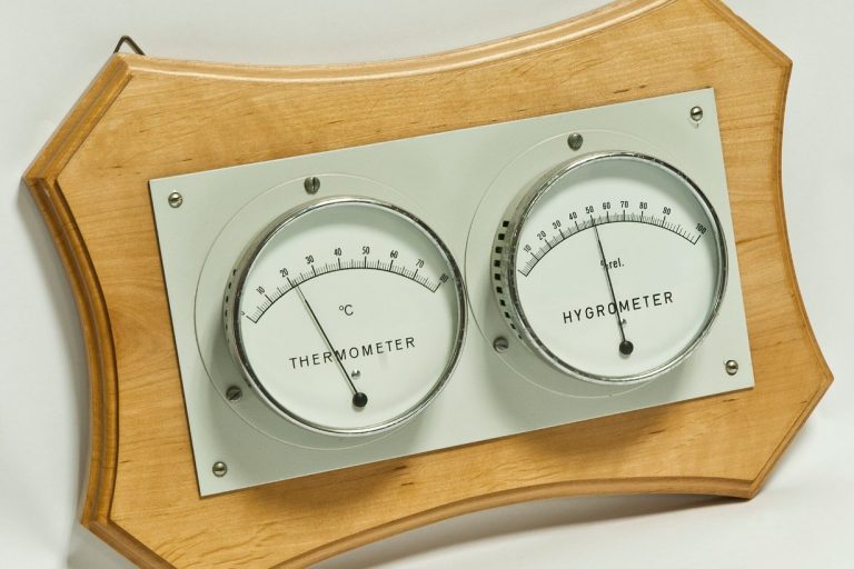 Analoges Thermometer und Hygrometer auf Holzbrett: Raumtemperatur und relative Luftfeuchte ablesen